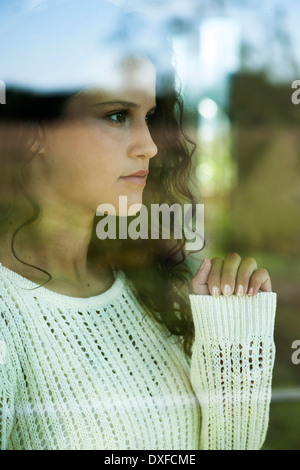 Close-up portrait of teenage girl looking out window, Allemagne Banque D'Images