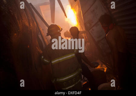 Guatemala City, Guatemala. Mar 25, 2014. Les pompiers pour éteindre un incendie au marché de la Terminal de la ville de Guatemala, capitale du Guatemala, le 25 mars 2014. Le feu a consommé plus de 100 locaux dans le marché, selon la presse locale. Crédit : Luis Echeverria/Xinhua/Alamy Live News Banque D'Images