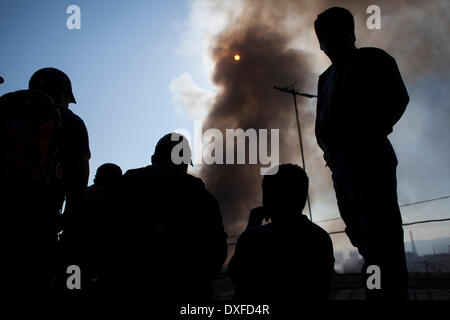 Guatemala City, Guatemala. Mar 25, 2014. Les gens regardent une épaisse colonne de fumée qui monte de la Terminal Market où un incendie se produit dans la ville de Guatemala, capitale du Guatemala, le 25 mars 2014. Le feu a consommé plus de 100 locaux dans le marché, selon la presse locale. Crédit : Luis Echeverria/Xinhua/Alamy Live News Banque D'Images