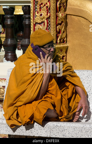 Un moine thaïlandais à l'aide d'un téléphone cellulaire au Doi Suthep Temple bouddhiste près de Chiang Mai dans le nord de la Thaïlande. Banque D'Images