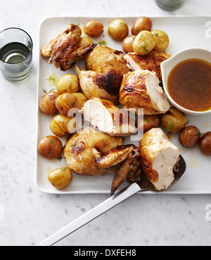 Faux-Tisserie poulet coupé en morceaux avec pommes de terre rôties sur assiette avec la sauce, studio shot Banque D'Images