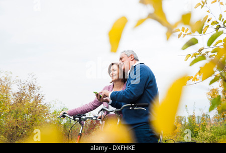 Couple avec des vélos à l'aide d'un téléphone cellulaire, Mannheim, Allemagne, Baden-Wurttmeberg Banque D'Images