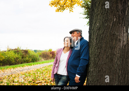 Couple leaning against Tree Trunk, Mannheim, Allemagne, Baden-Wurttmeberg Banque D'Images