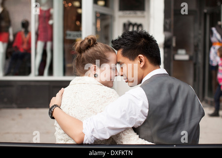 Close-up portrait of boy, couple sitting on bench on city Street, Toronto, Ontario, Canada Banque D'Images