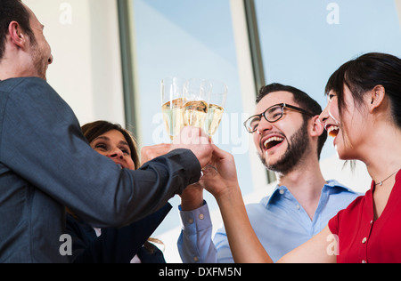 Les gens d'affaires et holding toasting each other in office, Allemagne Banque D'Images