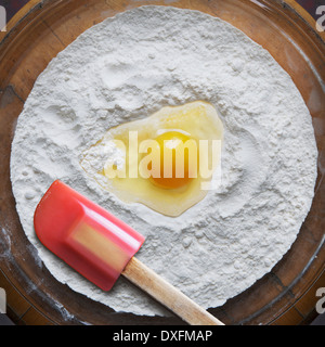 Close-up de farine et d'oeuf cru sur plat en verre avec spatule, studio shot Banque D'Images