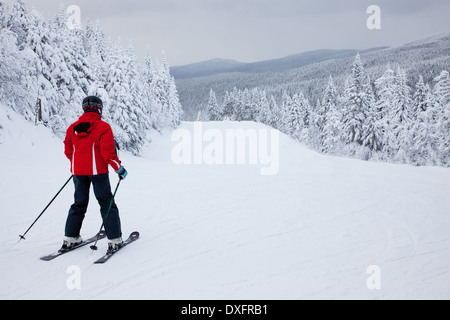 Mont-Tremblant, Québec, Canada - le 9 février 2014 : un seul skieur est glissant sur une pente facile à la station de ski Mont-Tremblant. Banque D'Images