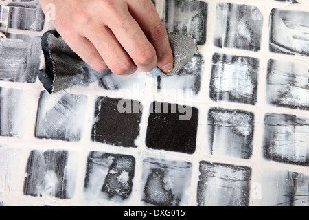 S'applique au travailleur de coulis carreaux gris Banque D'Images