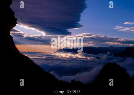 Voir le lever du soleil à partir de la grotte de Bell vers Cathkin Peak, au-dessus des nuages, Drakensberg Banque D'Images