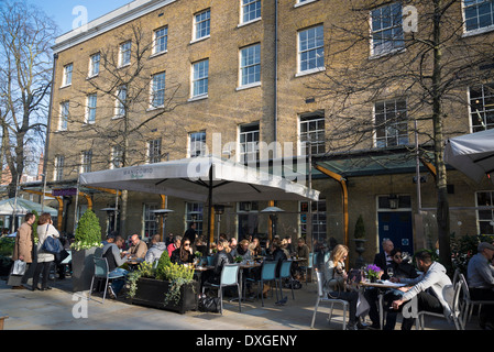 Des gens assis sur la terrasse de Manicomio restaurant et café, Duke of York Square, King's Road, Chelsea, London, UK Banque D'Images