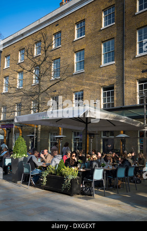 Des gens assis sur la terrasse de Manicomio restaurant et café, Duke of York Square, King's Road, Chelsea, London, UK Banque D'Images