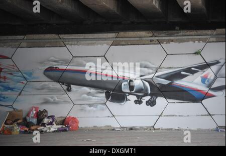 Kuala Lumpur, Malaisie. Mar 26, 2014. Un sans-abri prendre une sieste à l'écriture graffiti avec missin du vol MH370 de Malaysia Airlines affiche sur un mur à Kuala Lumpur le 26 mars 2014. Nouvelle 122 repéré des débris ne sont pas loin d'objets aperçus plus tôt par les Français et les satellites chinois a déclaré le ministre des Transports, intérimaire Datuk Seri HISHAMMUDDIN TUN HUSSEIN.Photo : Firdaus Latif/NurPhoto NurPhoto © Firdaus Latif//ZUMAPRESS.com/Alamy Live News Banque D'Images