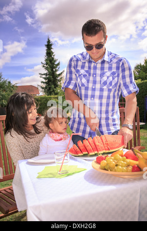 Jeune famille de manger dans le jardin Banque D'Images