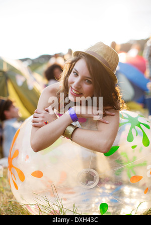 Portrait of happy woman leaning on chaise gonflable tentes à l'extérieur du festival de musique Banque D'Images