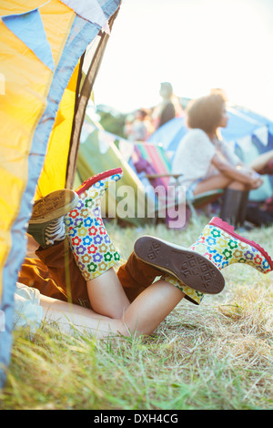 CoupleÍs les jambes hors de la tente à music festival Banque D'Images