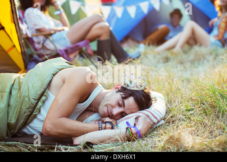 L'homme à tiara dormir dans des tentes à l'extérieur du sac de couchage au festival de musique Banque D'Images