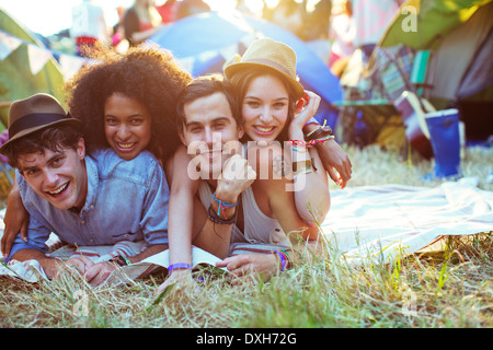 Portrait d'amis portant sur la couverture à l'extérieur des tentes au festival de musique Banque D'Images