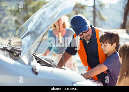 Boy watching roadside mechanic vérifier moteur de voiture Banque D'Images