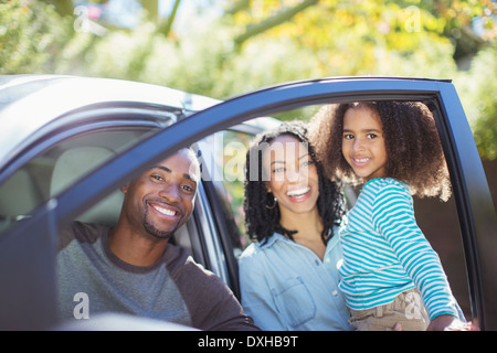 Portrait de famille heureuse à l'intérieur et l'extérieur de voiture Banque D'Images