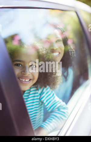 Portrait of smiling car looking out car window Banque D'Images
