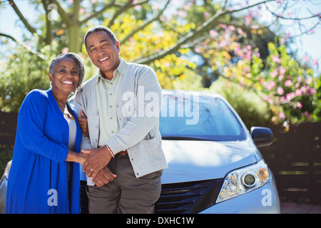 Portrait of happy senior couple leaning on car Banque D'Images