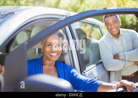 Portrait of happy senior couple intérieur et l'extérieur de voiture Banque D'Images