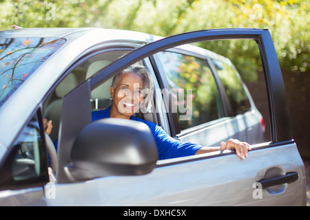 Senior woman getting out of car Banque D'Images