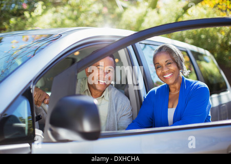 Portrait de couple heureux à l'intérieur et l'extérieur de voiture Banque D'Images