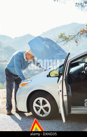 L'homme à la voiture à moteur au bord de la route Banque D'Images