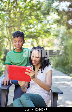 Mère et fils using digital tablet outdoors Banque D'Images