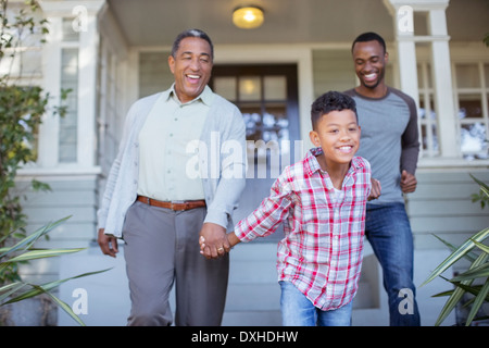 Multi-generation men holding hands outside house Banque D'Images