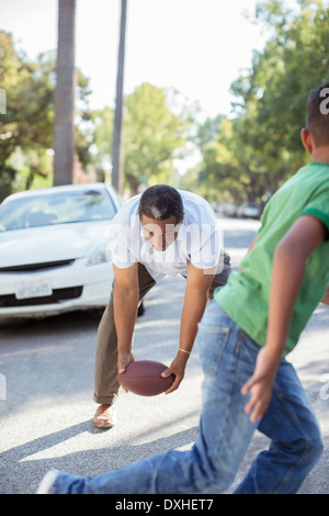 Grand-père et petit-fils jouant au football dans Street Banque D'Images