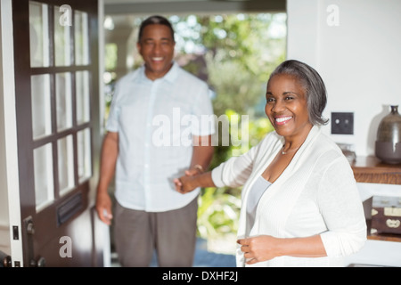 Portrait of smiling senior couple holding hands in doorway Banque D'Images