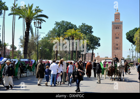 Le nord de l'angle de la place Djemma el Fna avec landaus et caleche en attente en arrière-plan la Koutoubia, Marrakech Banque D'Images