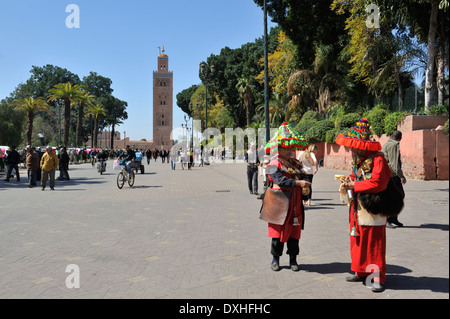 Habillé traditionnellement deux vendeurs d'eau en place Jemaa el-Fna avec en arrière-plan la Koutoubia, Marrakech, Maroc, Afrique du Nord Banque D'Images