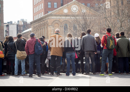 Les visiteurs du parc Washington Square dans le quartier de New York de Greenwich Village regarder les artistes interprètes ou exécutants dans la fontaine Banque D'Images