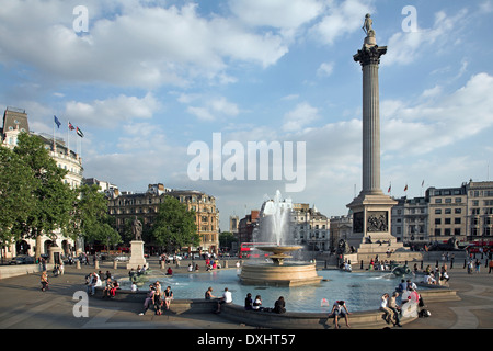 Les gens, une fontaine et la colonne Nelson à Trafalgar Square, Londres, Angleterre Banque D'Images