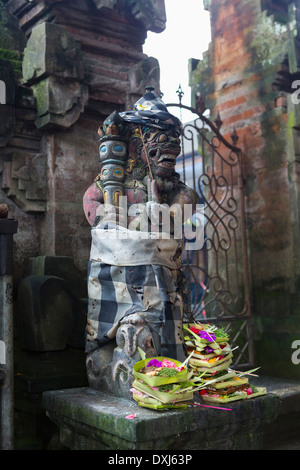 L'épargne à la base de la statue hindoue, Ubud, Bali, Indonésie Banque D'Images