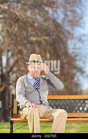 Man en tête assis sur banc en bois dans la région de park Banque D'Images