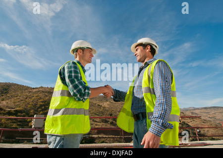 Deux ingénieurs en construction, shaking hands Banque D'Images