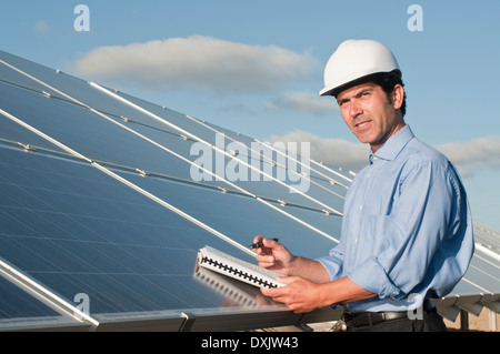 Ingénieur avec les plans et panneaux solaires Banque D'Images
