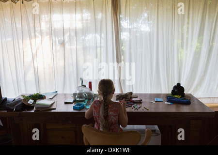 Caucasian girl coloring at desk Banque D'Images