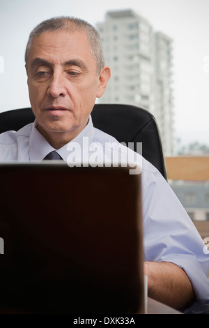 Close up of Hispanic man using laptop in office urbain Banque D'Images