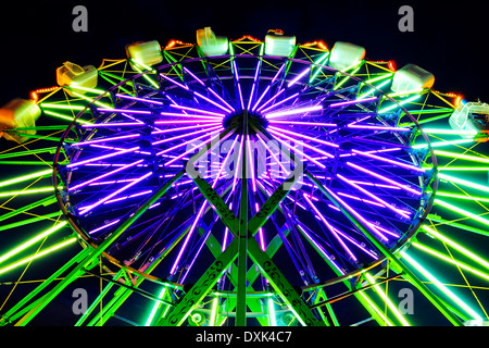 Grande Roue néon ride at amusement park at night Banque D'Images