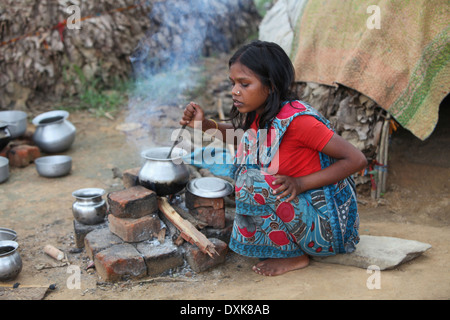 Femme Tribal à la cuisson des aliments sur l'âtre. Bhuija Musahar ou tribu. Keredari et village, district de bloc Hazaribaug, Jharkhand, India. Banque D'Images