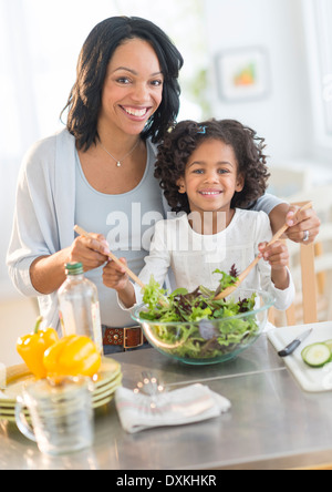 African American mother and daughter tossing salad Banque D'Images