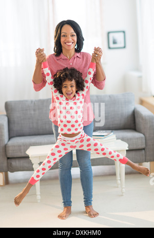 African American mother lifting daughter joyeusement Banque D'Images