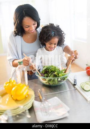 African American mother and daughter tossing salad Banque D'Images