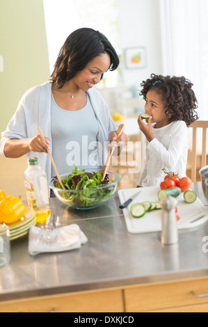 African American mother and daughter tossing salad Banque D'Images