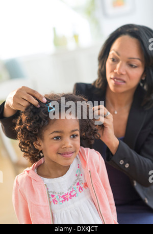 African American mother fixing daughter's hair Banque D'Images